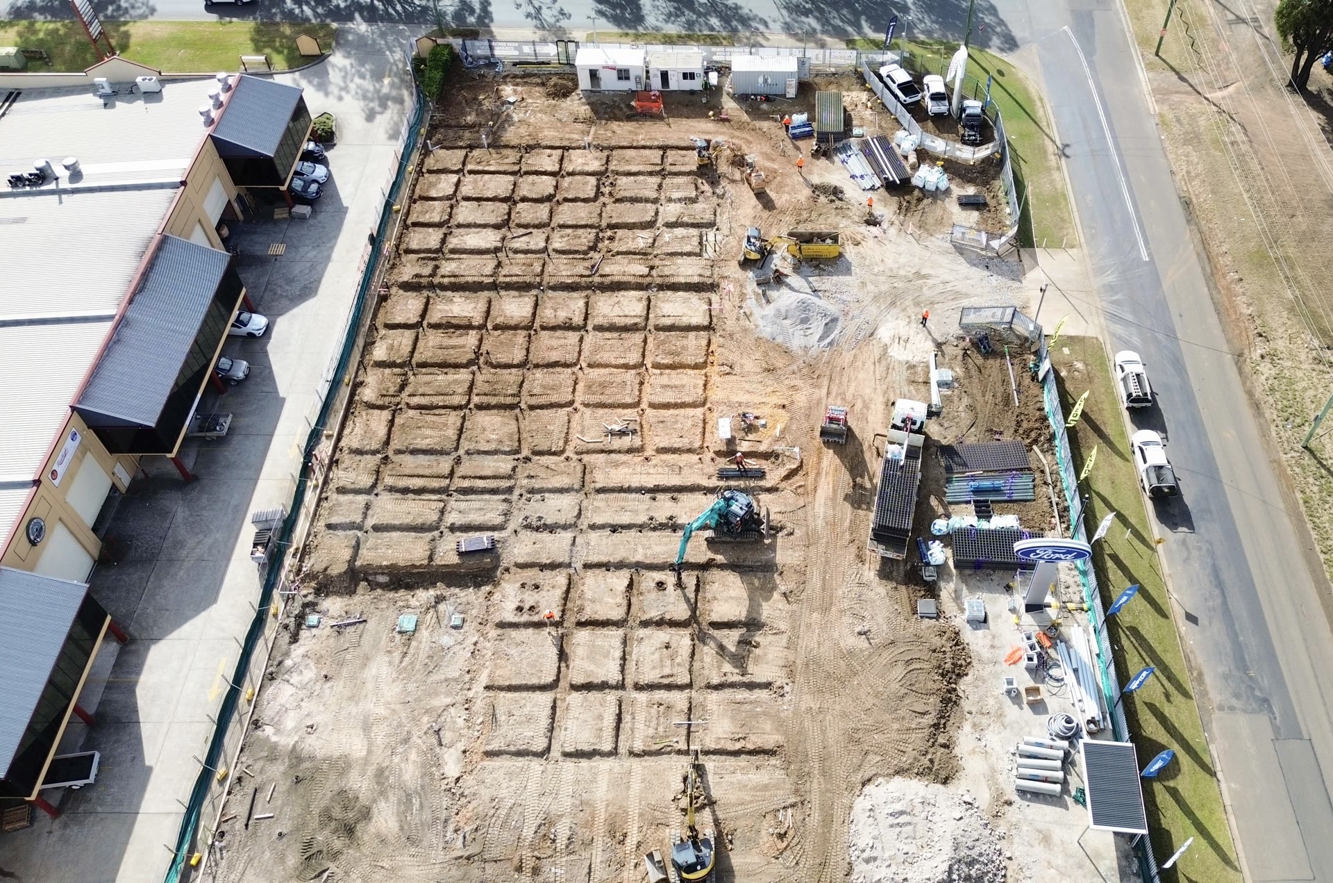 Aerial view of the foundation layout and piling equipment across a large construction site